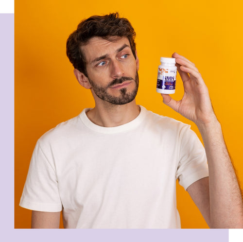 Photo of young man holding a bottle of NMN